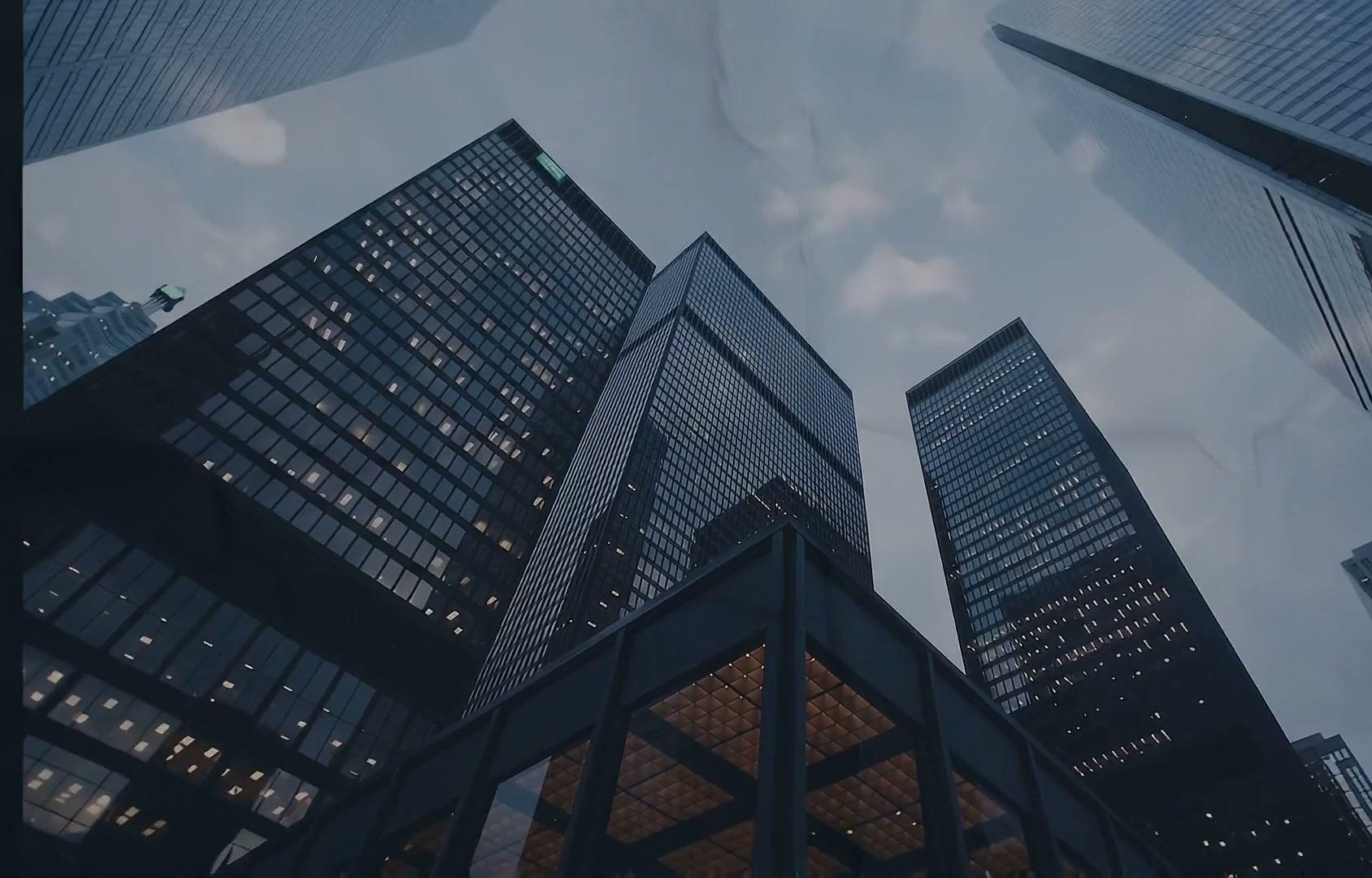 Torres corporativas de vidro vistas de baixo ao entardecer, com janelas iluminadas